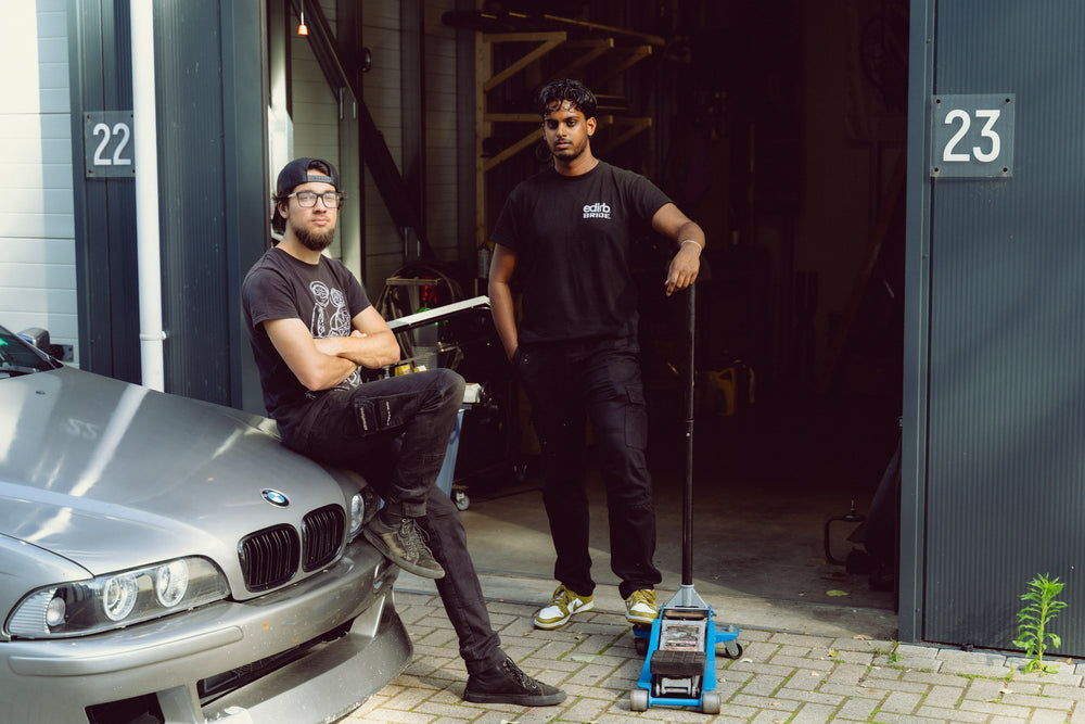 Het team van Stein Fab poserend bij een zilveren BMW E39 voor hun tuning werkplaats en garagebox 23.