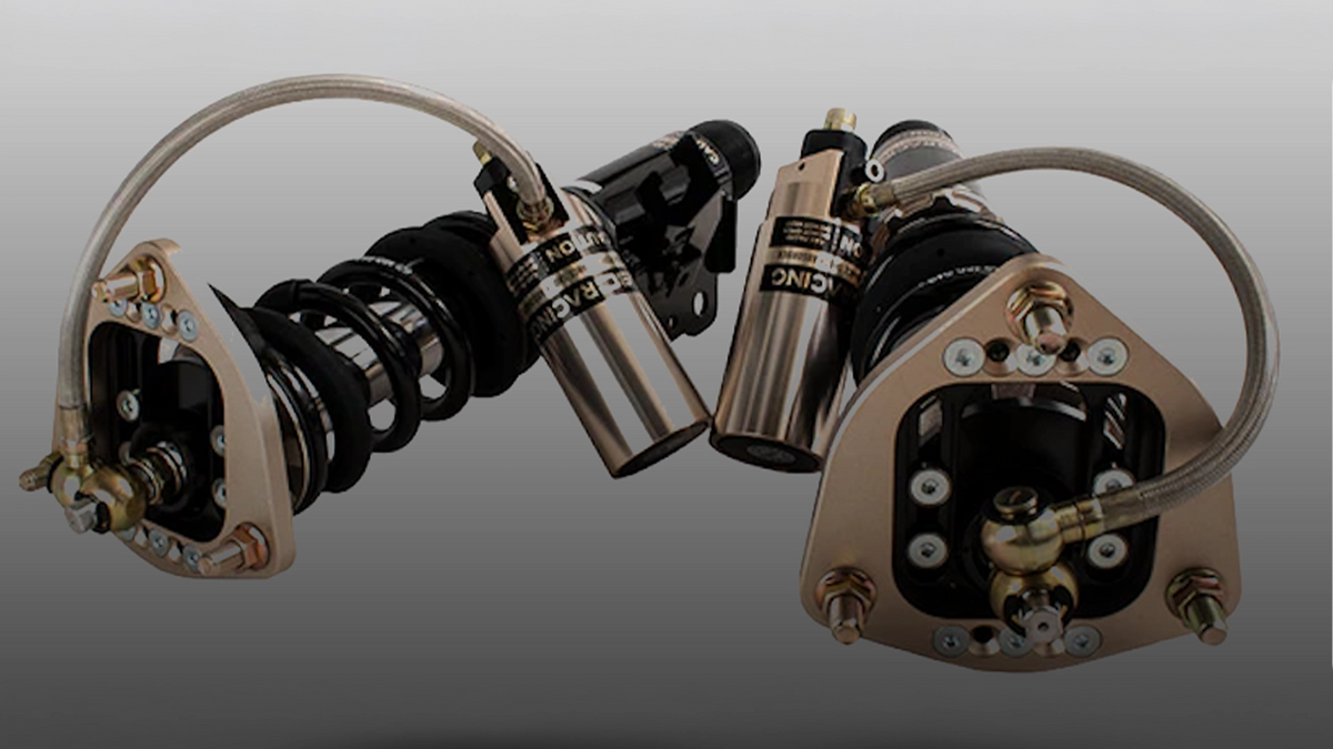 BC Racing schroefset met externe reservoirs en goudkleurige verstelbare toplagers voor circuitwagens.