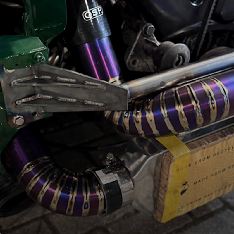 Custom TIG-gelaste titanium intercooler buis met paarse hitteverkleuring en een QSP siliconen koppeling.